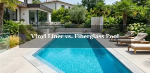A gorgeous modern backyard pool with glossy, vibrant blue water and elegant stone deck coping, featuring the text overlay "Vinyl Liner vs. Fiberglass Pool".